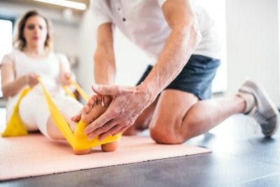 fisioterapeuta trabaja con el paciente durante la rehabilitación del accidente cerebrovascular en el tronco del cerebro