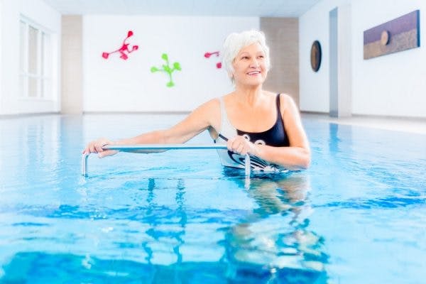 survivor in pool waiting to train with therapist after learning of the benefits of aquatic therapy for spinal cord injury