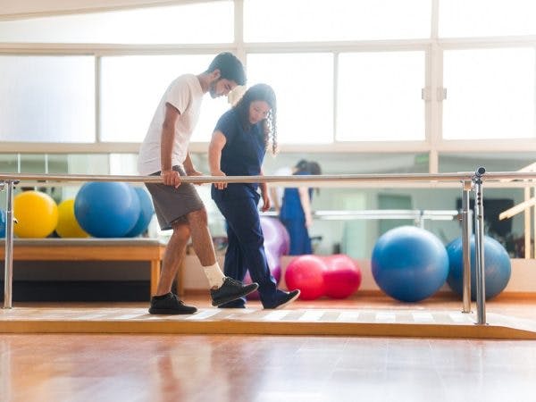 therapist helping survivor with ataxia improve their balance