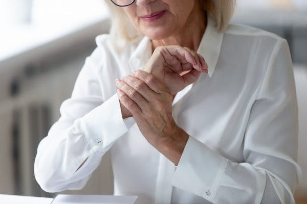 woman with spinal cord injury using tenodesis grasp to compensate for hand paralysis