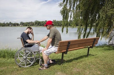 father helping son manage depression after spinal cord injury
