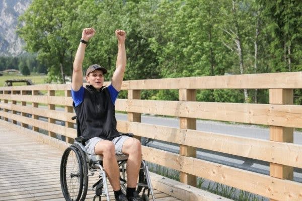 young man that is paralyzed from waist down using a wheelchair