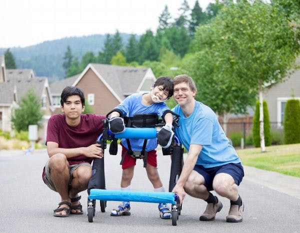 boy with abnormal walking pattern called crouch gait due to cerebral palsy using a walker