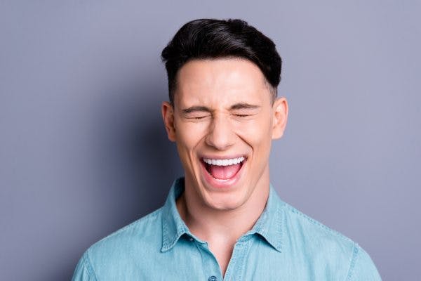 man closing eyes and smiling because he has disinhibition after brain injury