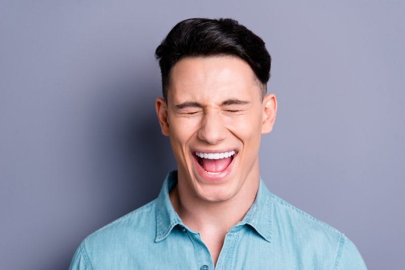 man closing eyes and smiling because he has disinhibition after brain injury