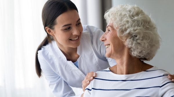 nurse helping elderly patient with global aphasia