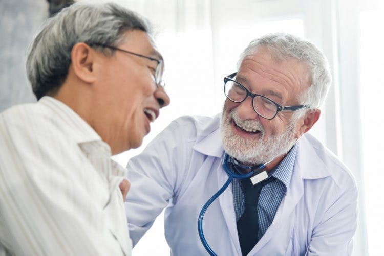 friendly speech language pathologist talking with stroke patient about recovery