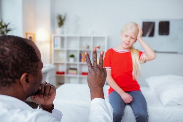 doctor holding up three fingers to diagnose children with traumatic brain injury