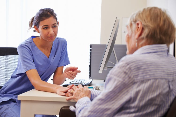 elderly patient in doctor's office discussing transcortical motor aphasia with doctor