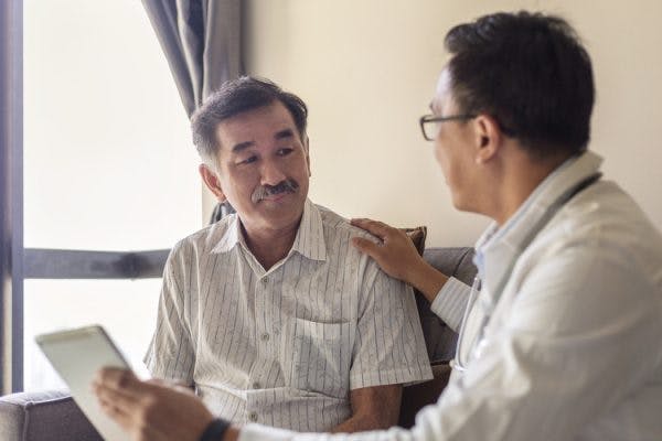 doctor talking to patient with agnosia holding up tablet
