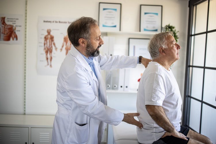 doctor checking survivor experiencing tingling and numbness after spinal cord injury