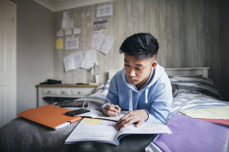 person studying from various books after brain injury