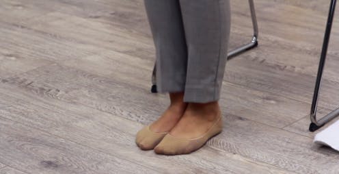 Une thérapeute pose ses pieds pour effectuer un exercice bilatéral qui vise le pied tombant.