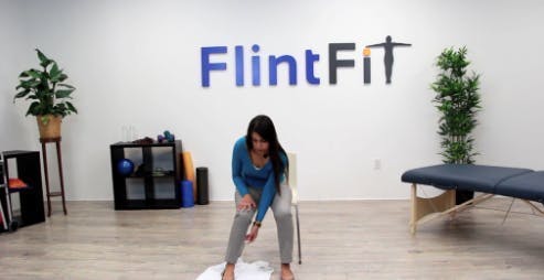 Une thérapeute se pose pour effectuer un exercice en faisant tourner les hanches qui rend le noyau fort, ce qui contribue à améliorer le pied tombant.