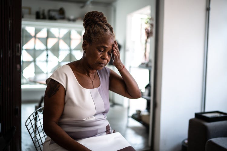 woman with fatigue after brain injury rubbing her temples