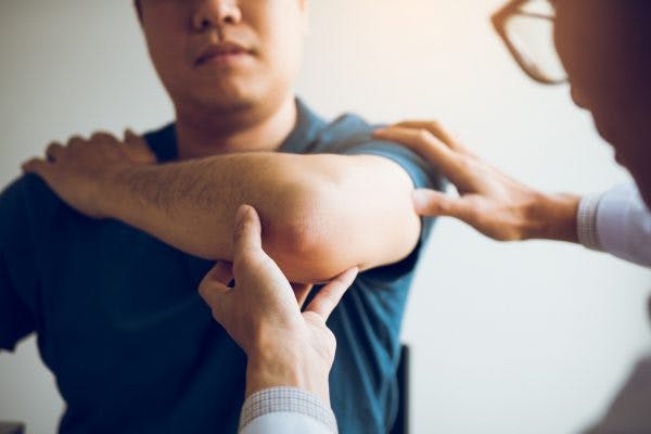 Physical therapist checking patient's flexion synergy patterns after stroke