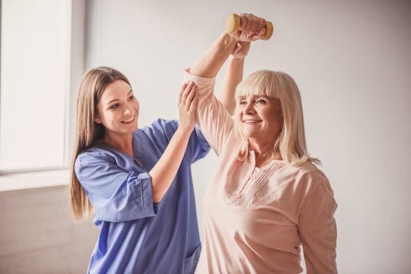 therapist working with stroke patient towards a full recovery
