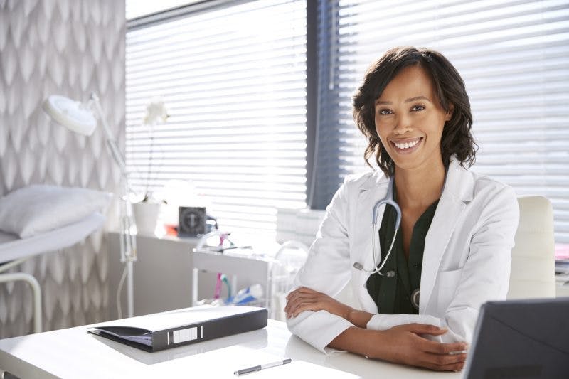 doctor sitting at desk reviewing signs of recovery from stroke