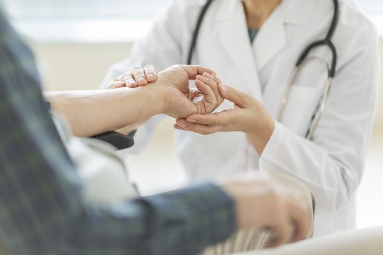 therapist helping patient with grasp and release activities stroke