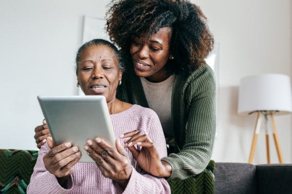 caregiver helping brain injury survivor practice short term memory exercises on tablet