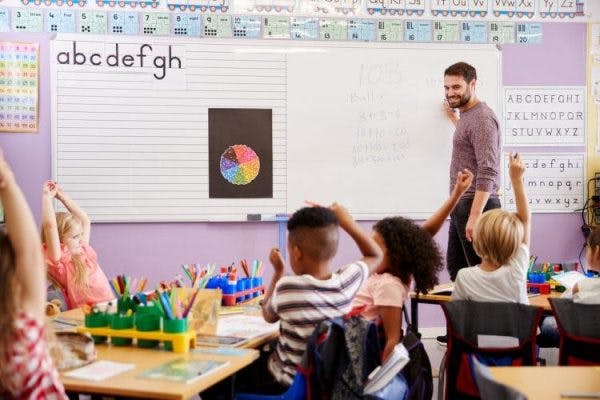 teacher supporting child with cerebral palsy in the classroom
