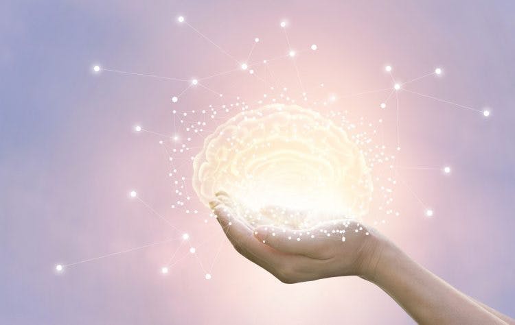 illuminated brain glowing in a person's hands to show how it heals itself after stroke
