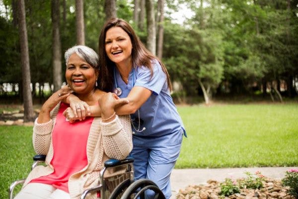 caregiver hugging woman in wheelchair demonstrating signs and symptoms of cerebral palsy throughout all life stages