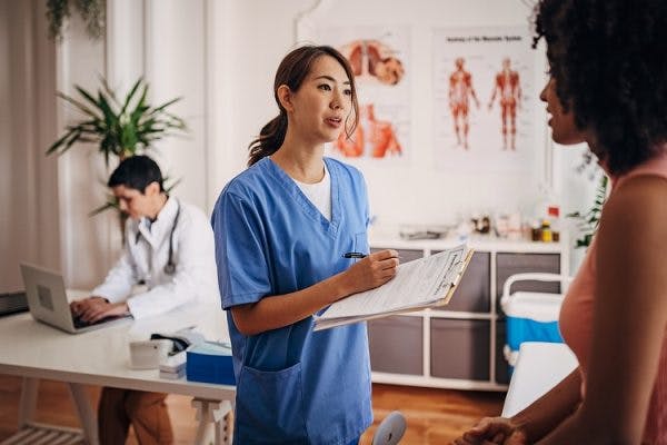 doctor and nurse discussing long-term effects of mild traumatic brain injury with patient