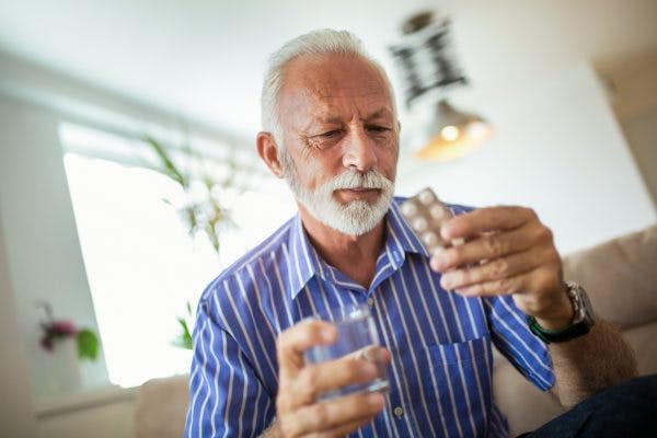 Senior man tat home taking memantine pills for TBI