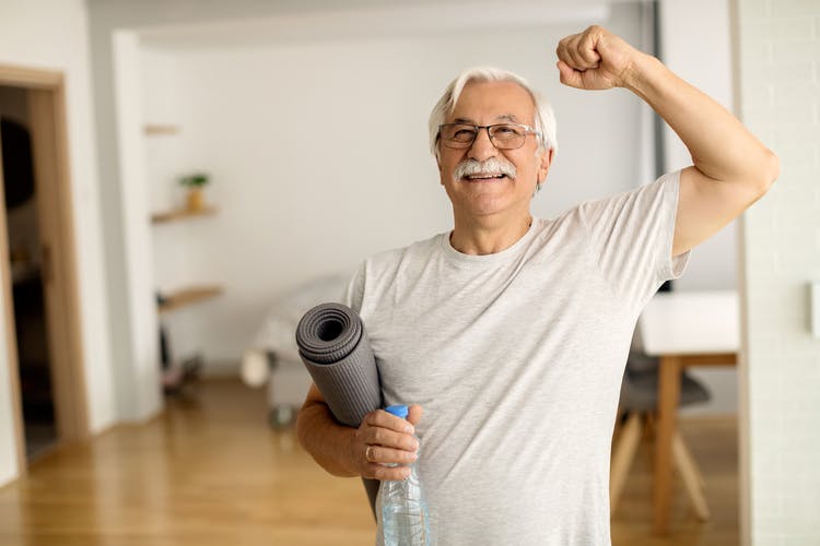 healthy mild stroke survivor holding a yoga mat after exercising at home