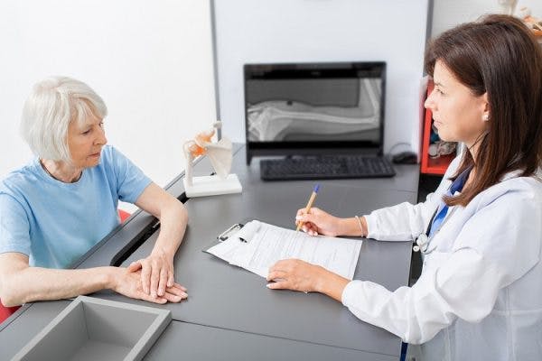 doctor discussing muscle twitching after head injury with patient