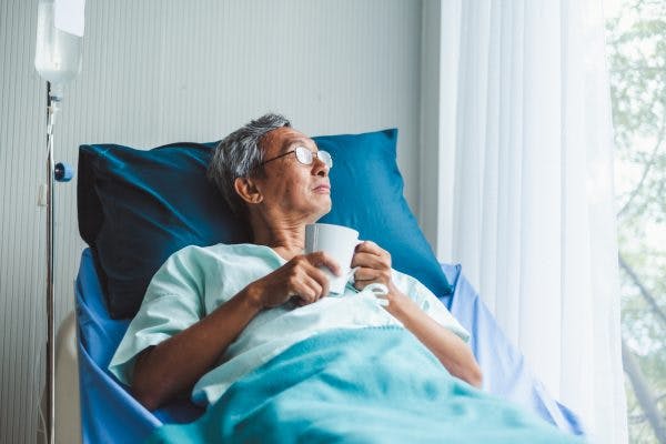 stroke patient in hospital bed with IV fluids being treated for cyclic vomiting