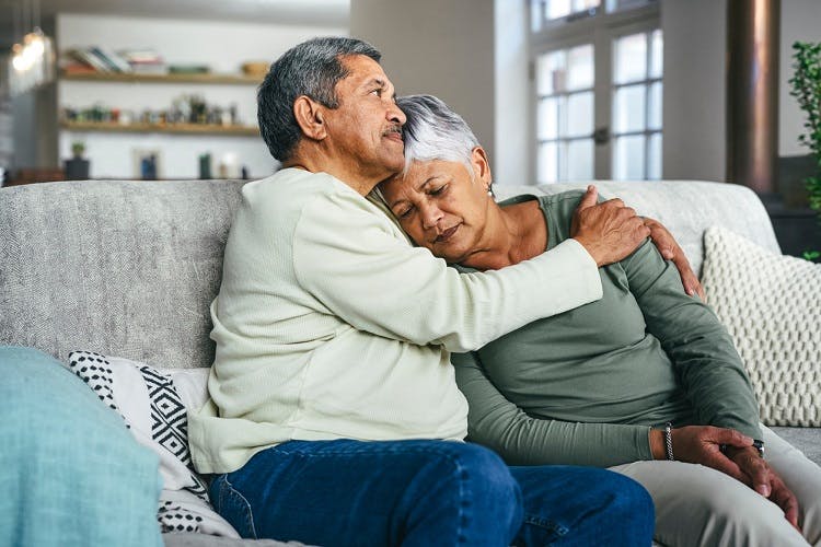 husband hugging and consoling his wife going through grief after stroke