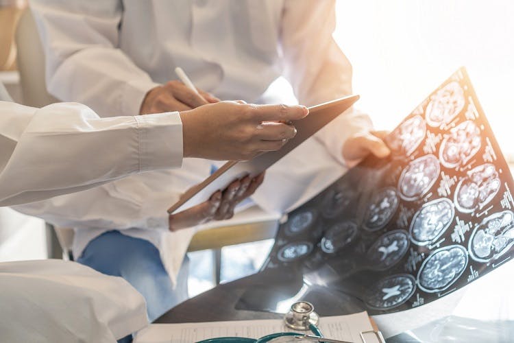 ER doctors with brain scans discussing treatments for traumatic brain injury and the aftermath