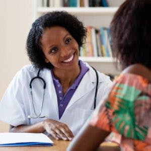 Médico amablemente trabajando con paciente con accidente cerebrovascular para ayudarla a comprender los efectos del accidente cerebrovascular del lóbulo temporal