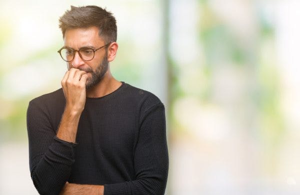man biting his nails from paranoia and TBI