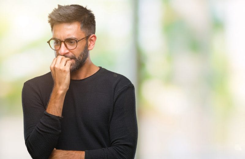 man biting his nails from paranoia and TBI
