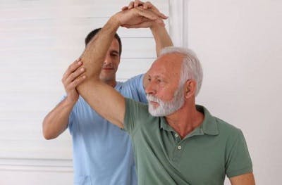 spinal cord injury patient practicing passive range of motion exercises with physiotherapist