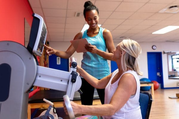 Therapist helping TBI patient with rehab equipment