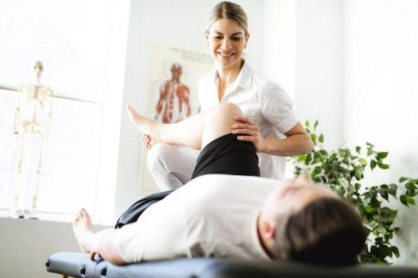 physiotherapist doing exercises for stroke patients with paralysis on therapy table