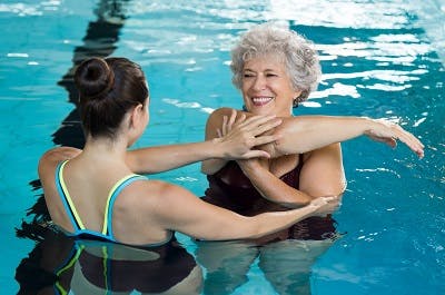 woman with spinal cord injury practicing exercises in a pool