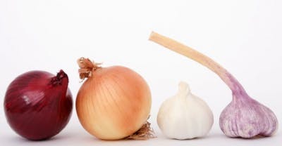 Quatre oignons en divers couleurs contenant des antioxydants qui amendent la récupération après un AVC.