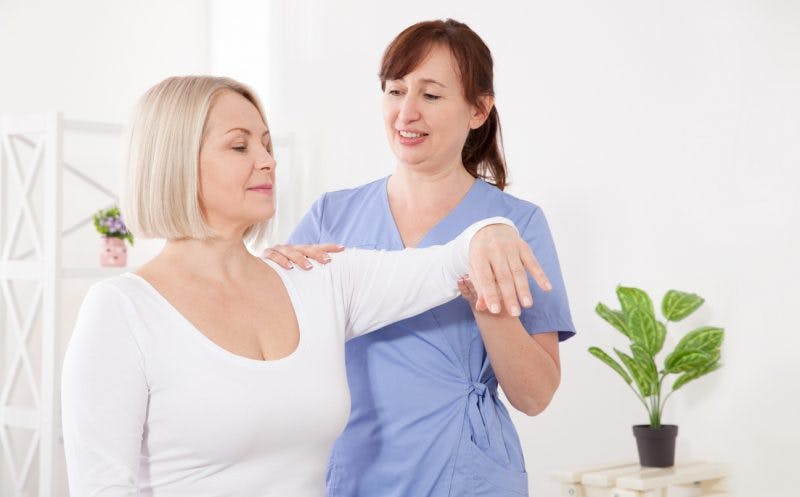 physiotherapist helping a stroke patient to use compensatory strategies safely