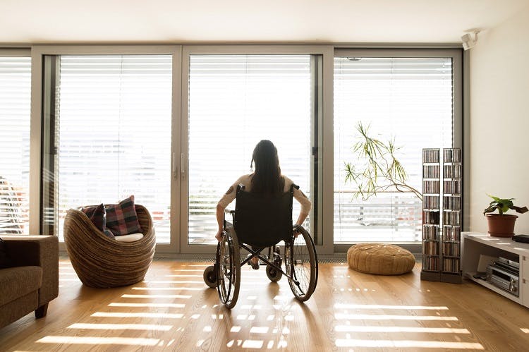 survivor sitting on a wheelchair thinking about the potential spinal cord injury complications that can occur