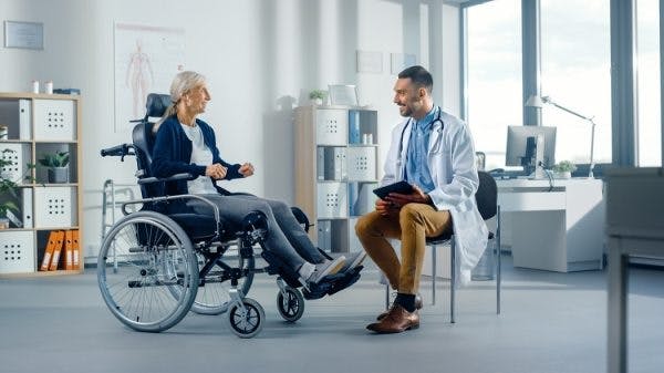 woman in a wheelchair speaking to her therapist about the effects of a spinal cord injury