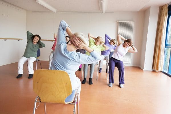 therapist guiding spinal cord injury patients through sitting balance exercises in clinic