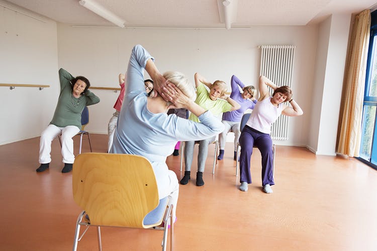 therapist guiding spinal cord injury patients through sitting balance exercises in clinic