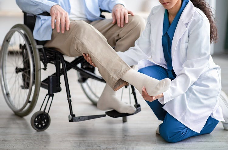 doctor examining patient's leg to determine spastic vs flaccid paralysis