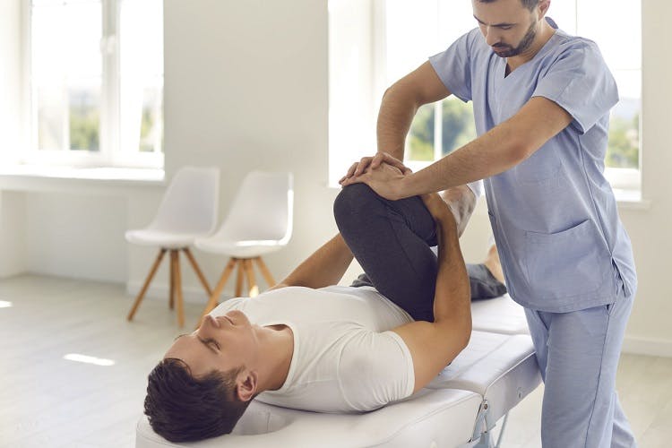 indiviual experiencing spasticity after spinal cord injury participating in physical therapy to stretch muscles