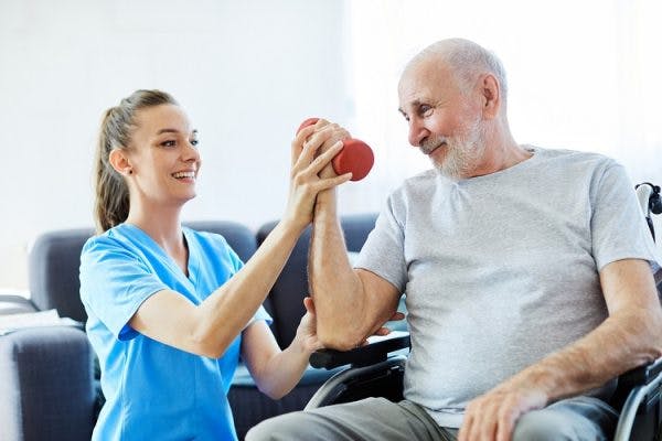 therapist performing passive exercises with patient to improve spinal cord injury paralysis
